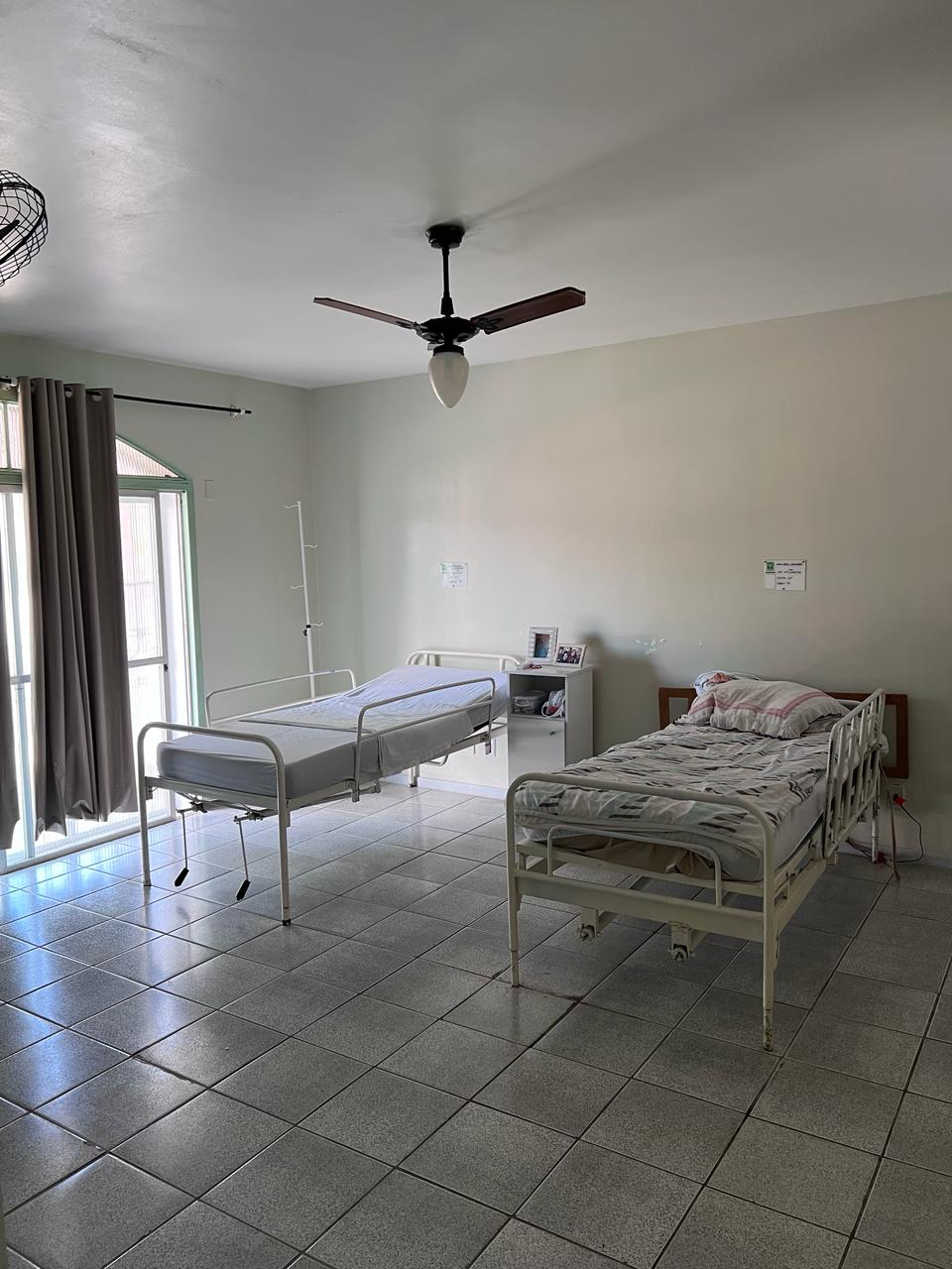 Quarto com camas hospitalares e ventilação